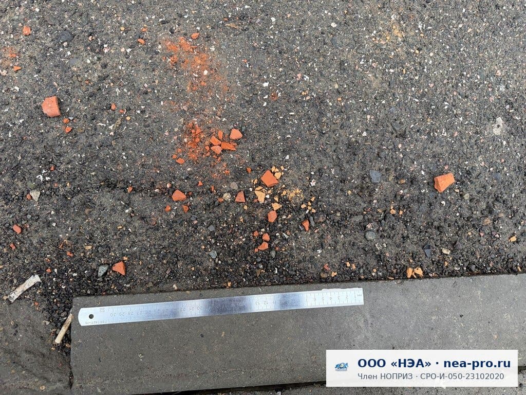 Осыпь кирпичной крошки и обломков у стены дома