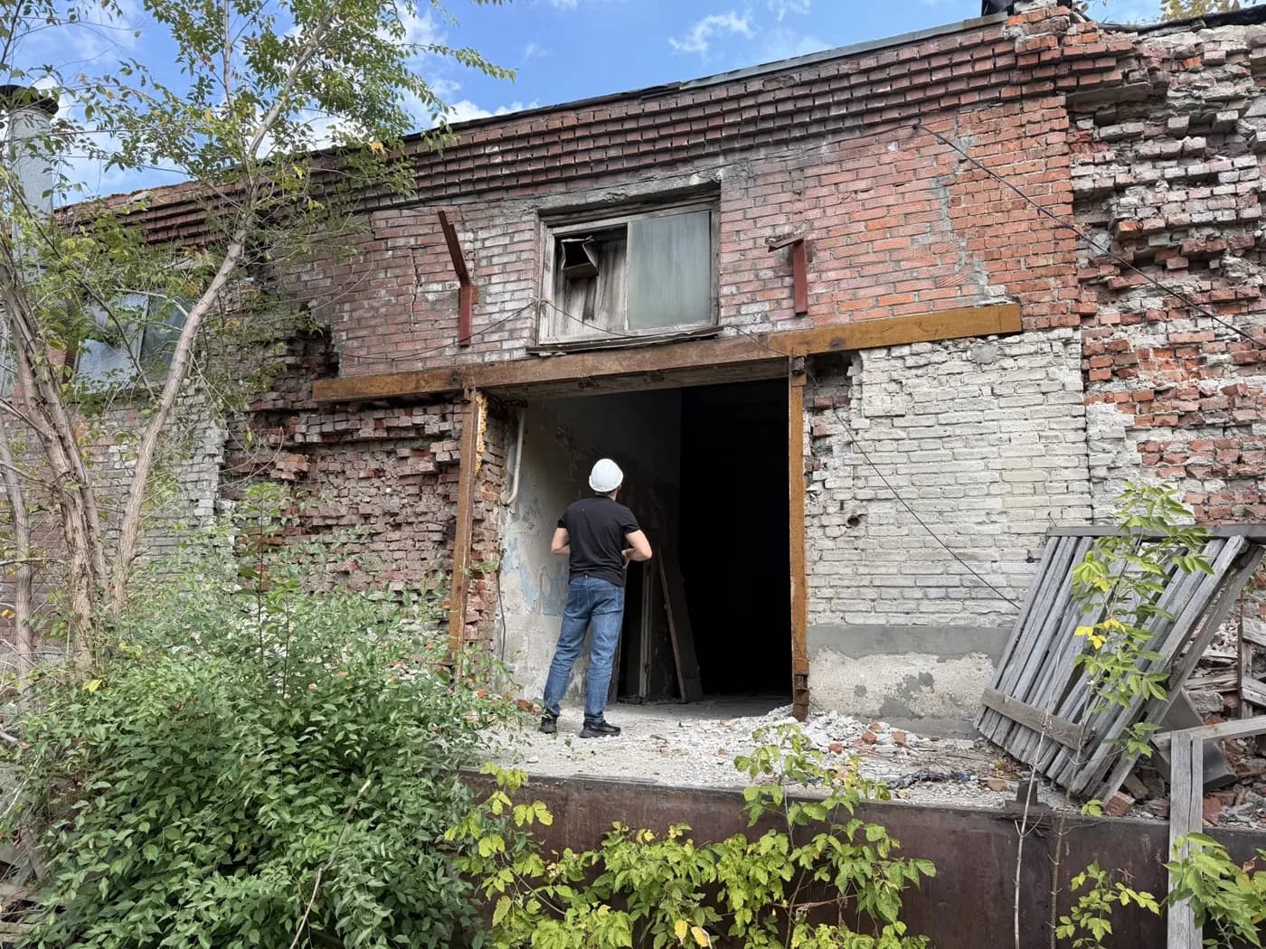 Осмотр разрушенной кирпичной кладки над проёмом производственного здания